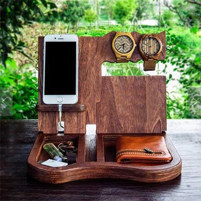 Dark wood-grain desk organiser holding a phone, two watches, keys and wallet as usage examples