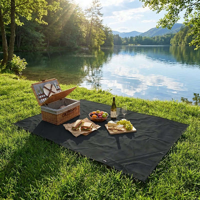Frontier Torrent Camping Blanket spread on grass by a lake, ideal for picnics and outdoor adventures.