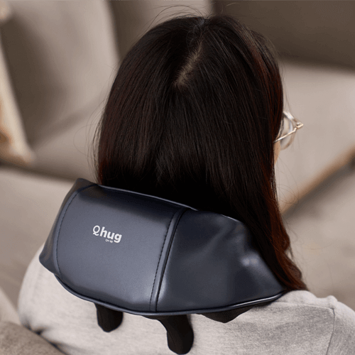 User enjoying the OTO Q Hug massager for neck and shoulder relief from a corporate gift store.