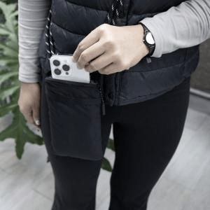 Person using the BrandCharger Pico Crossbody Bag to hold a smartphone in a compact and stylish manner.
