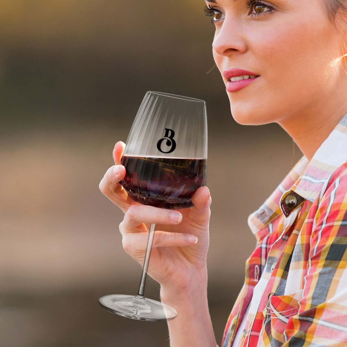 Enjoying a glass of wine in the Luigi Bormioli Optica Chardonnay Glass, perfect for a corporate gift in Singapore.