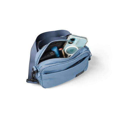 Crossing Sam Anti-Theft RFID Crossbody Bag in blue, showcasing interior items like phone and small essentials.