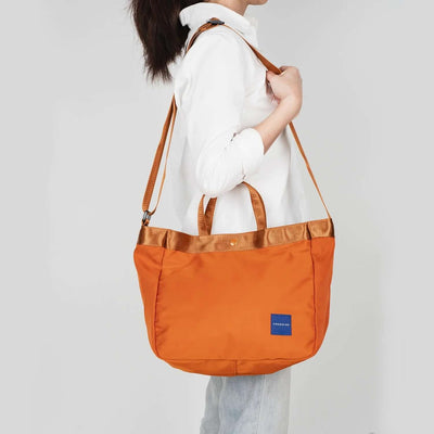 Crossing Hollis Anti-Theft RFID Dual Carry Crossbody Bag in orange, showcasing adjustable straps and stylish design.