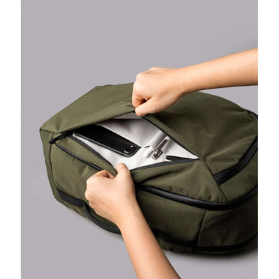 Close-up of hands opening the ALPAKA Traverse Backpack 30L top pocket, showcasing organization for tech gear.