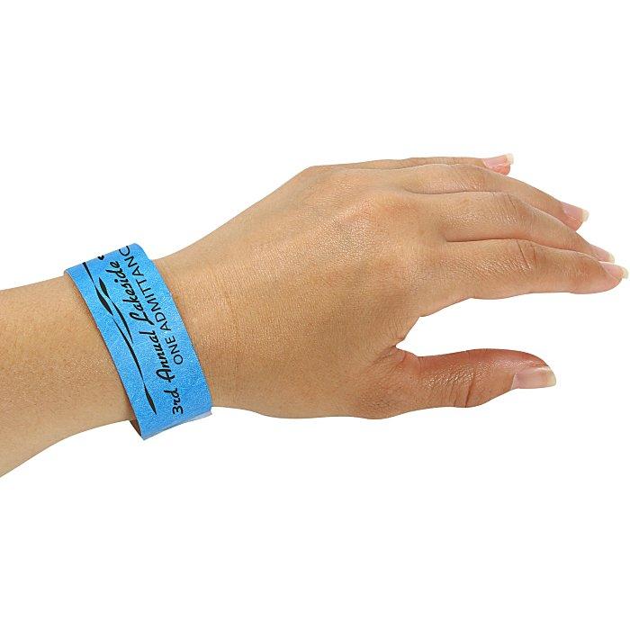 Blue printed event wristband worn around a wrist to illustrate its fastening and fit