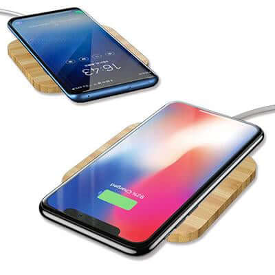 Illustrative phones positioned on rectangular wood-finish charging pads