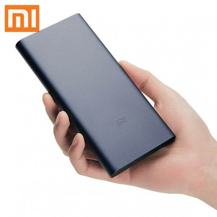 Dark blue Xiaomi Mi power bank held in one hand, showing the slim rectangular body and Mi logo