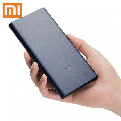 Dark blue Xiaomi Mi power bank held in one hand, showing the slim rectangular body and Mi logo