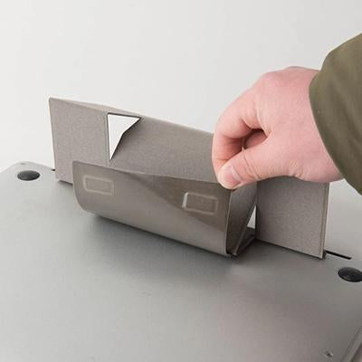 Hand demonstrating how the grey folding laptop stand panel opens beneath the laptop
