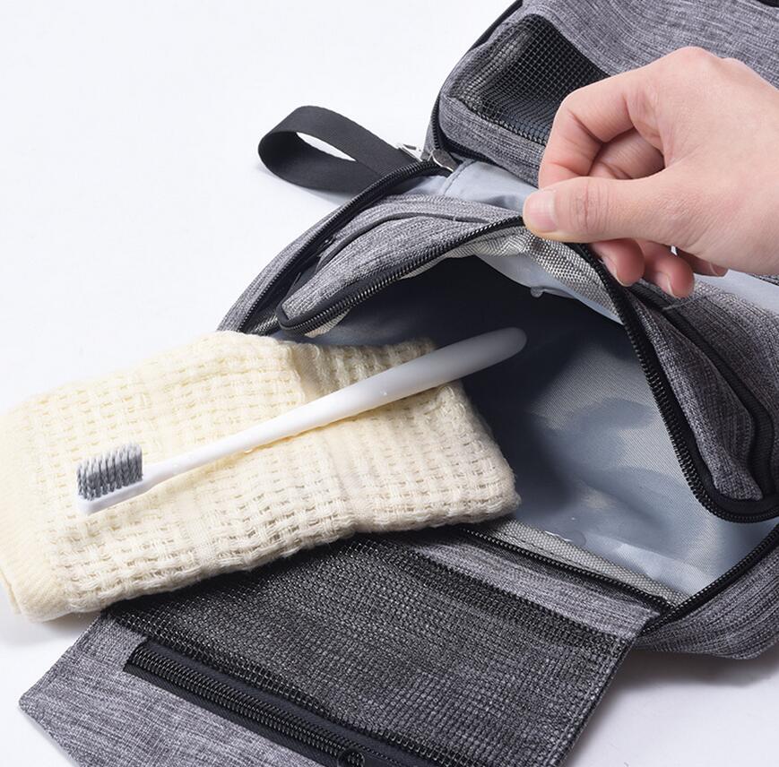 Open toiletry pouch showing mesh zip pocket and divided storage with sample travel items