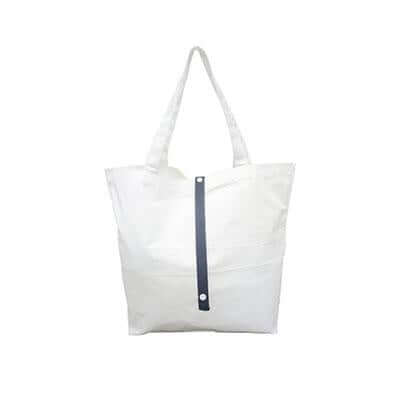 Natural-coloured canvas tote bag with long handles and a dark vertical fastening strap