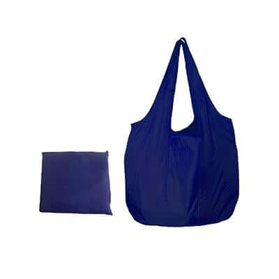 Navy foldable nylon tote with two handles beside a compact matching pack