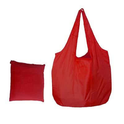 Red foldable nylon tote with two handles beside a compact matching pack